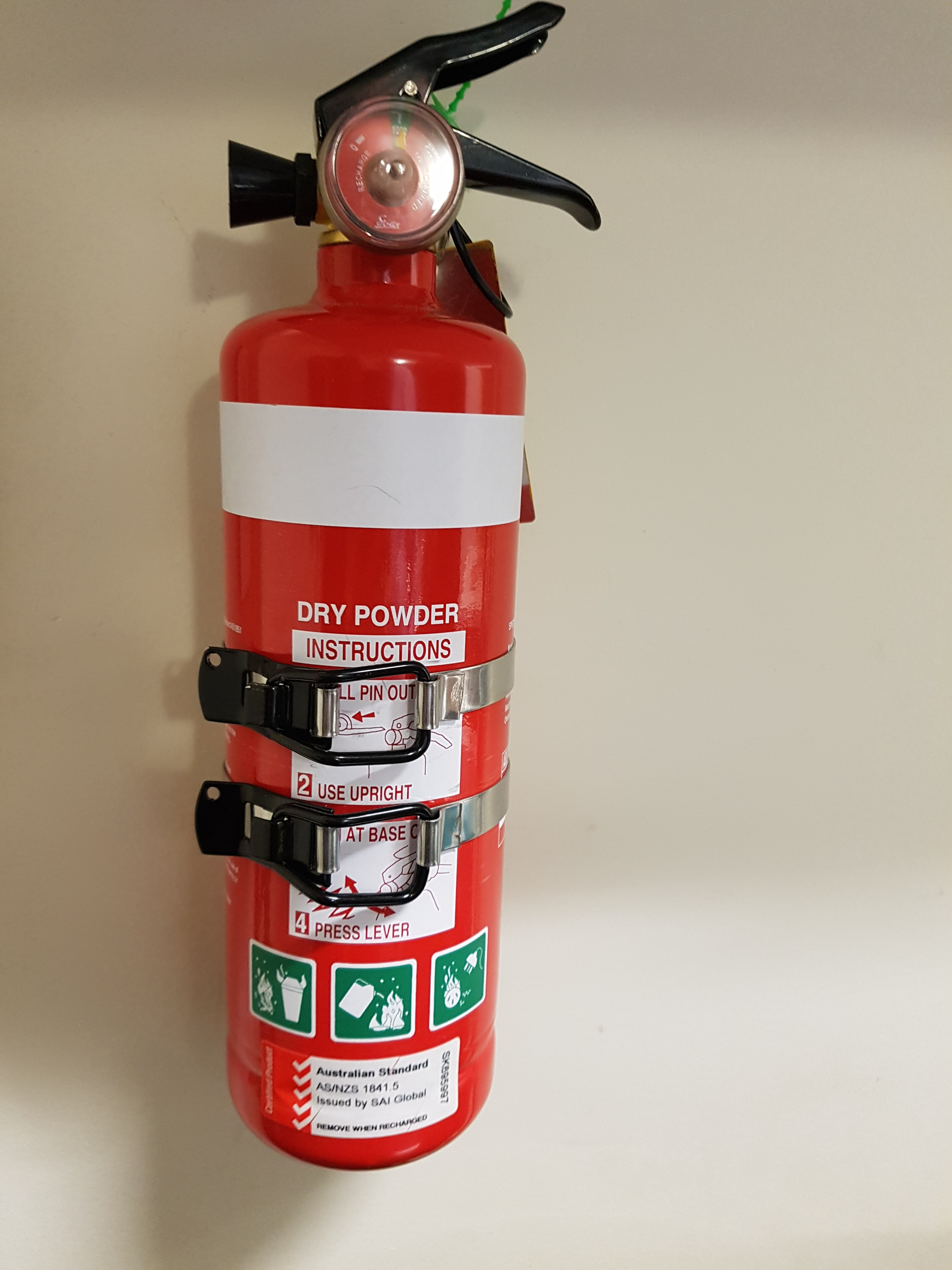 Fire Extinguisher fixed to bracket which has been installed on hollow wall with self aligning Scorpion Wall Plugs